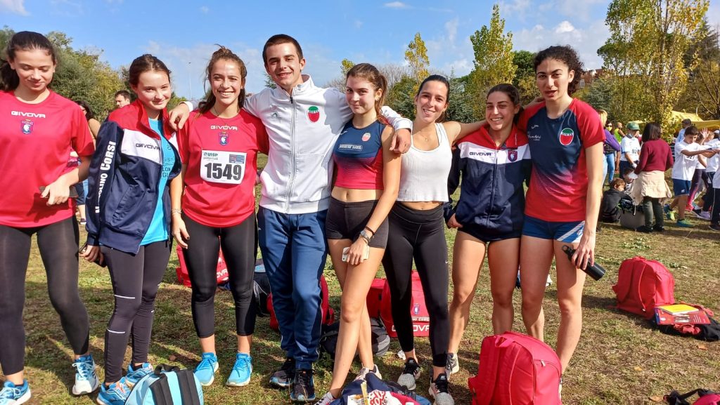 Foto di gruppo della squadra di atletica leggera allenata da Nissolino Atletica AREA Roma,  in primo piano i ragazzi, sullo sfondo alberi del parco